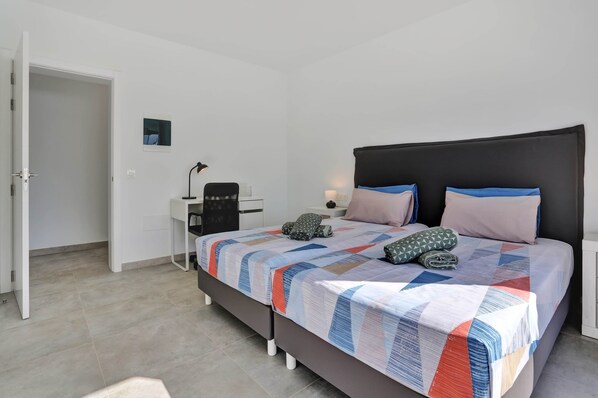 Un dormitorio con una cama, un escritorio y una silla.