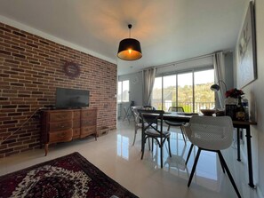 Relax in this stylish living space with a brick accent wall and expansive outdoor views.