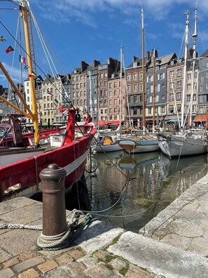 Boats are moored at the marina, surrounded by buildings with a clear view of the sky.
