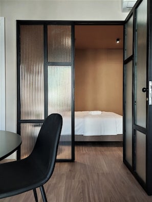 A compact room with a bed, a chair, and a table.