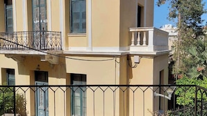 A two-story building with a balcony, a table, and two chairs. - Terrazzo City Apts (Heraklion)