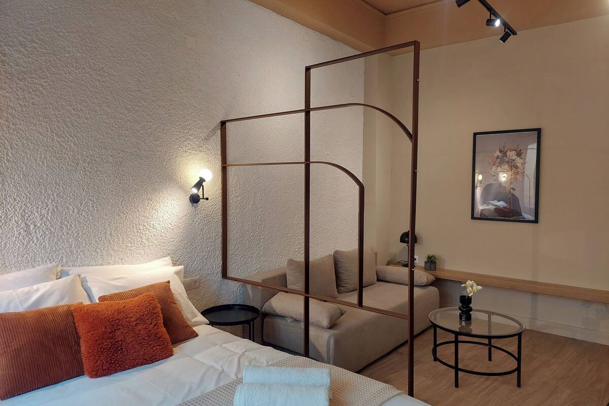 Een moderne hotelkamer met een groot bed, een zithoek en een kleine tafel.