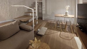 A modern living room with a bunk bed, a sofa, a dining table with chairs, and a staircase. - Terrazzo City Apts (Heraklion)