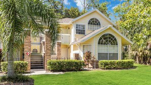 A two-story house with a front porch, a garage, and a well-maintained lawn.