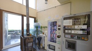 A room with a large window, a stove, a vending machine, and a sign for PADI Dive. - New Beachscape (Jeju City)