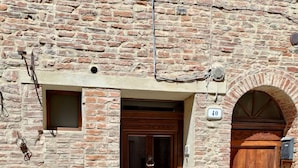 A brick building with a wooden door and a small window.