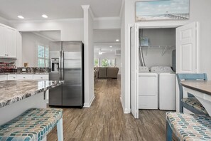 A modern kitchen with a stainless steel refrigerator, a built-in water dispenser, and a granite countertop.