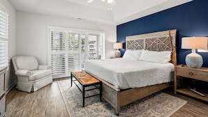 A bedroom with a bed, a chair, a nightstand, a lamp, a ceiling fan, and a view through the window. - Rare find in the heart of North Myrtle Beach (North Myrtle Beach)