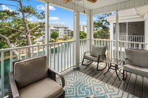 A covered outdoor deck with a view of a body of water and buildings in the background. - Rare find in the heart of North Myrtle Beach (North Myrtle Beach)