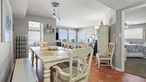 A spacious living area with a dining table, chairs, and a view of the sea. - Indulge in stunning views from this expansive oceanfront condo featuring a large balcony and pool (North Myrtle Beach)