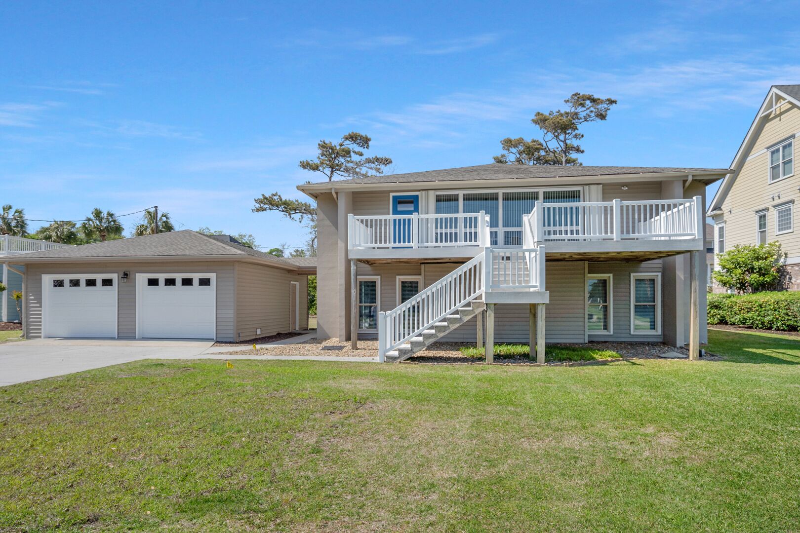 A two-story house with a front deck and a garage.