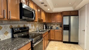 Una cocina moderna con armarios de madera, electrodomésticos de acero inoxidable y encimera de granito.