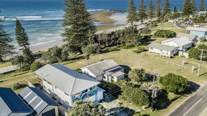 A coastal residential area with houses, a beach, and a view of the ocean. - Aqua Vista - Beach Front Location (Brooms Head)