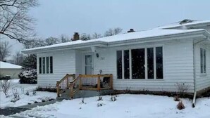A single-story house with a front porch, a garage, and a snow-covered roof. - PROMO 10% WEEKLY AND 15% MONTHLY!
Spacious & Quaint Home Game Room LOTS of Beds! (wheaton)