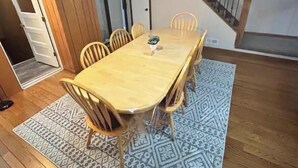 A dining area with a wooden table and chairs, a patterned rug, and a staircase in the background. - PROMO 10% WEEKLY AND 15% MONTHLY!
Spacious & Quaint Home Game Room LOTS of Beds! (wheaton)