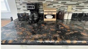 A kitchen with a coffee maker, a wooden bar sign, and jars on the counter.