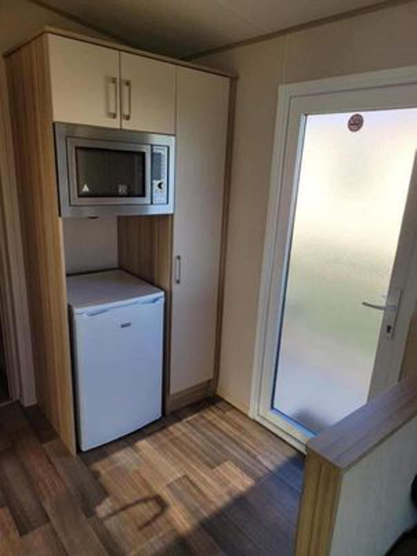 A compact kitchenette with a microwave, a small refrigerator, and a cabinet.