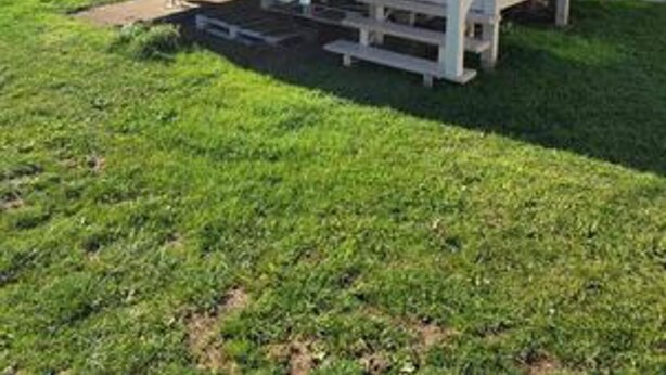 Una casa móvil con un porche delantero y una pequeña terraza.