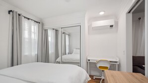 Une chambre d’hôtel avec un grand lit, un bureau avec une chaise et un miroir.
