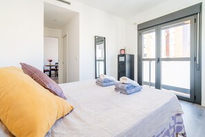 A bedroom with a bed, pillows, a desk with a chair, a wardrobe, and a large window. - Cubo's La Union Apartment Pool Optional Parking / urban / air conditioning / free wifi (Málaga)