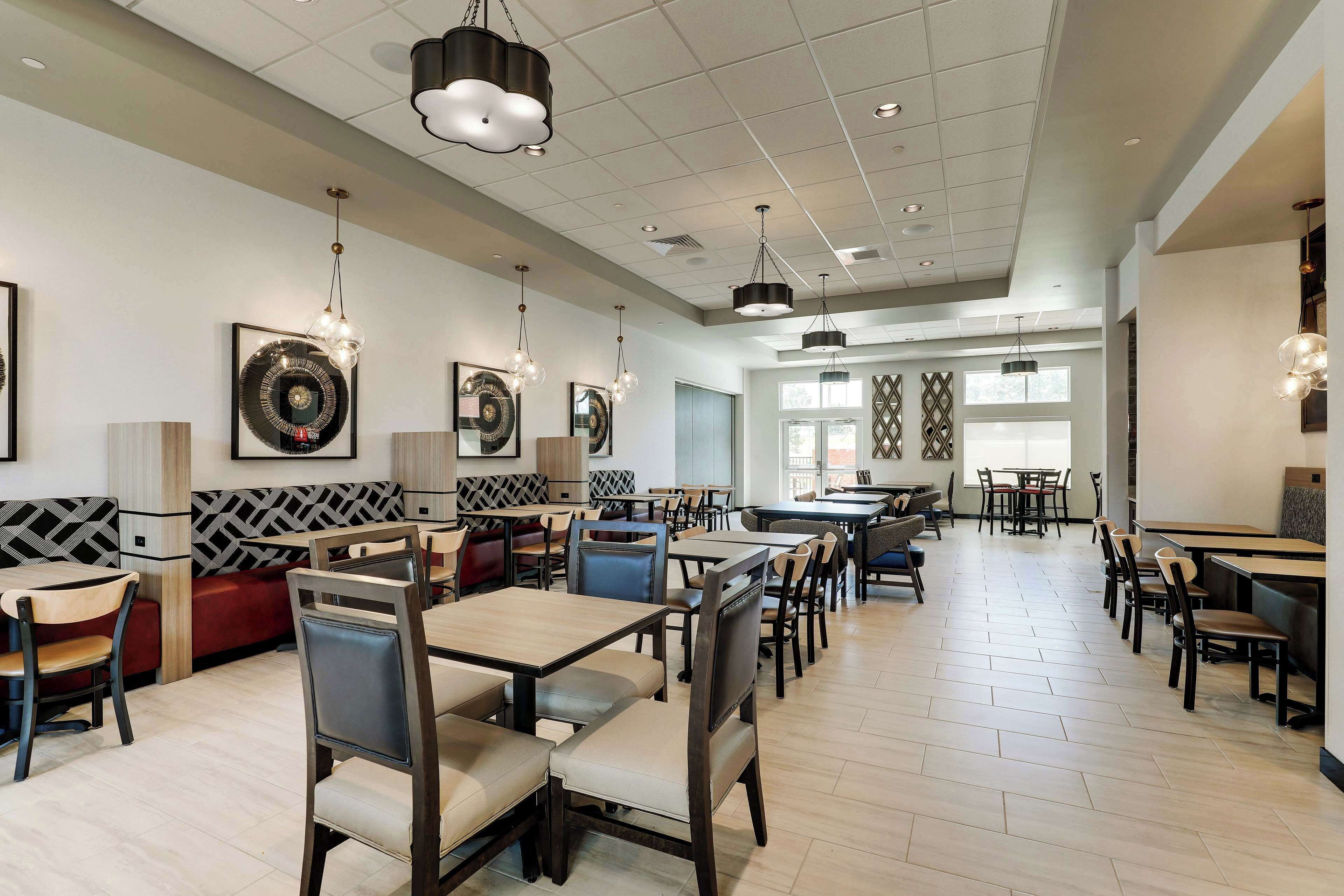A spacious restaurant with multiple dining areas, including booths and tables.