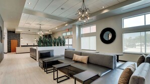 A modern lobby with a seating area, a reception desk, and large windows. - Drury Plaza Hotel Savannah Pooler (Pooler)