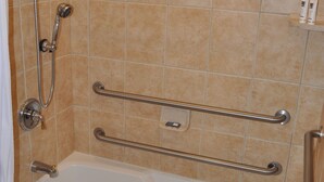 A bathroom with a bathtub, a shower, and grab bars. - Queen downstairs room (cayucos)