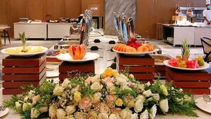 Una mesa de buffet con diferentes opciones de comida y un centro de mesa floral.