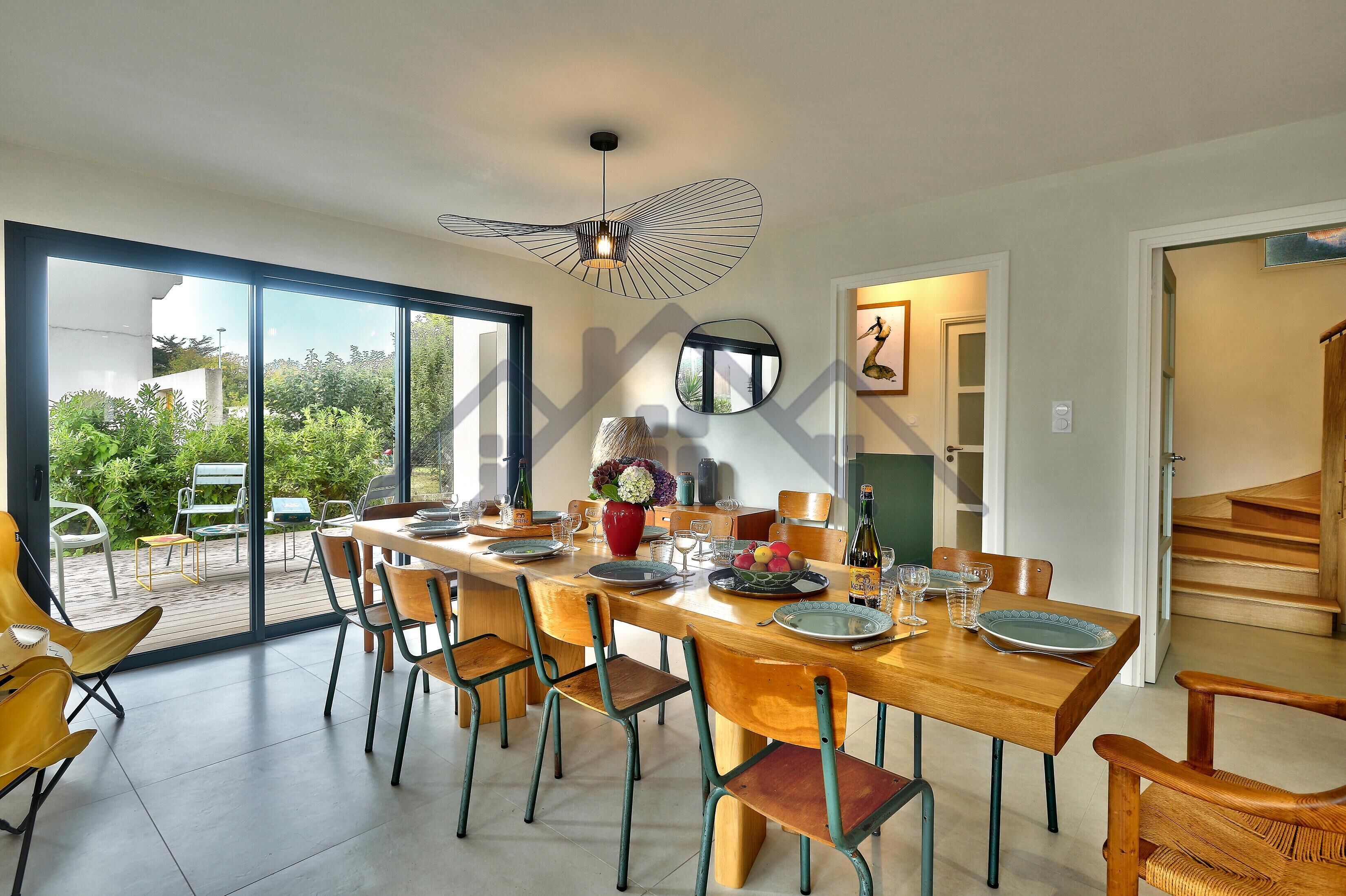 A dining area with a large table, chairs, and a ceiling fan.