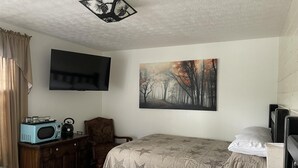 A bedroom with two beds, a TV, a painting, and a vintage radio. - Room with wi-fi, mini fridge and microwave Red River Gorge area (Clay City)