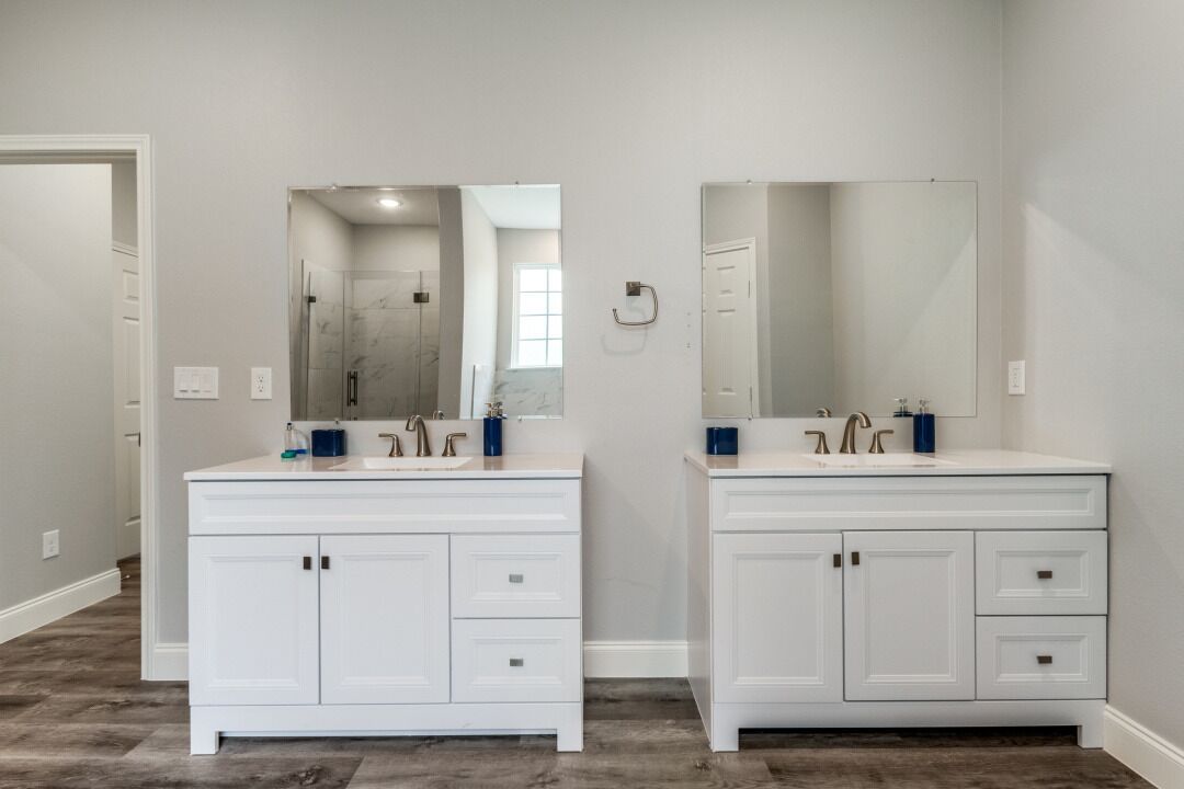 Un baño con dos tocadores blancos, cada uno con un espejo y un lavabo.