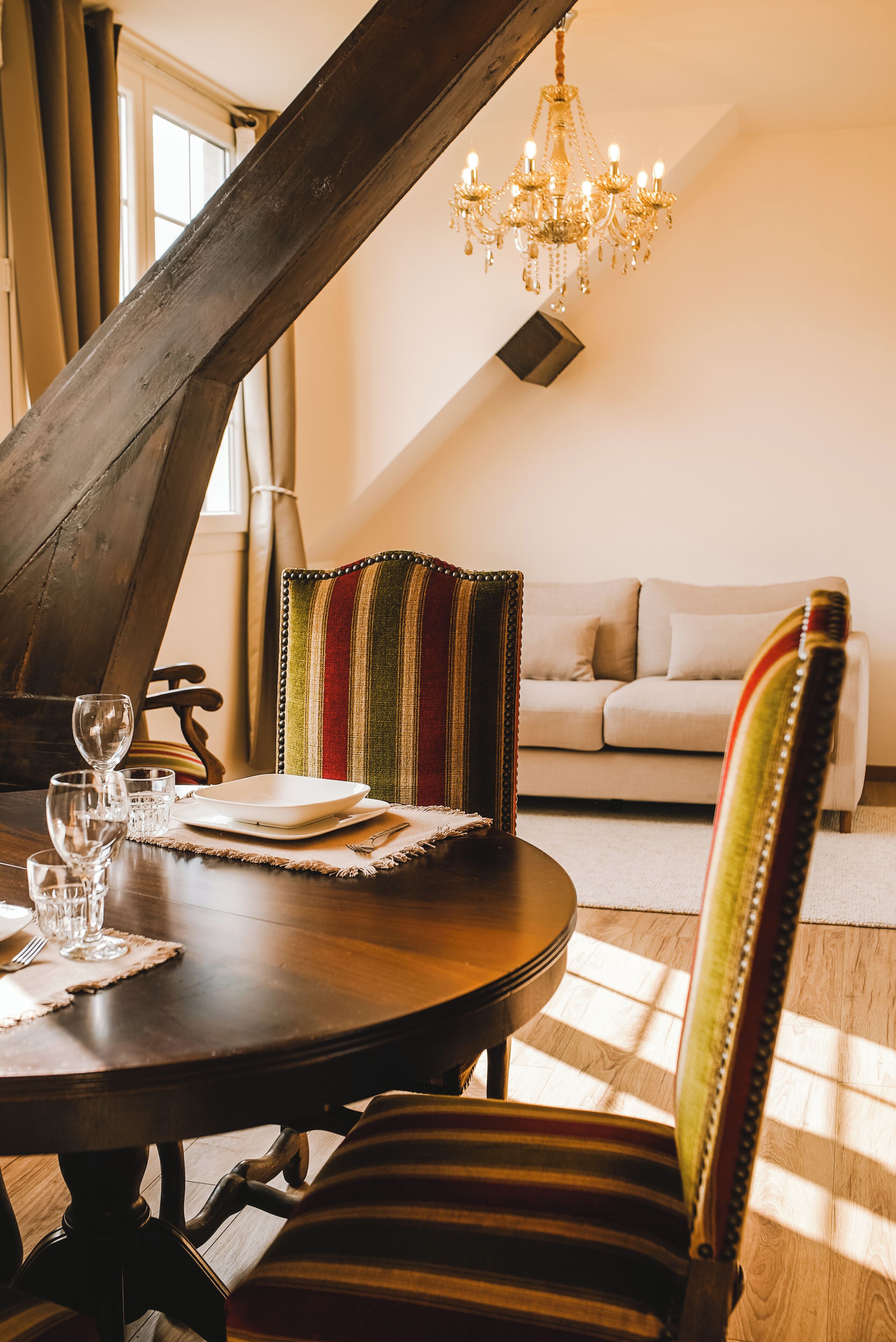 Un coin repas avec une table en bois, des chaises et un lustre.