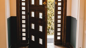 A wooden door with a grid pattern, leading to a room with a wooden floor. - Normandy Etretat (Etretat)