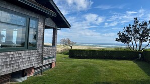 Une maison avec une grande fenêtre donnant sur une plage.