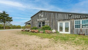 A rustic wooden building labeled "WM WINERY" with a gravel driveway and large rocks in front. - Spacious Owensville Getaway w/ Winery On-Site! (Owensville)