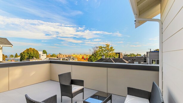 A balcony with wicker furniture and a clear view of the cityscape. - Highgarden The Tyrell House Sweet Suite (Seattle)
