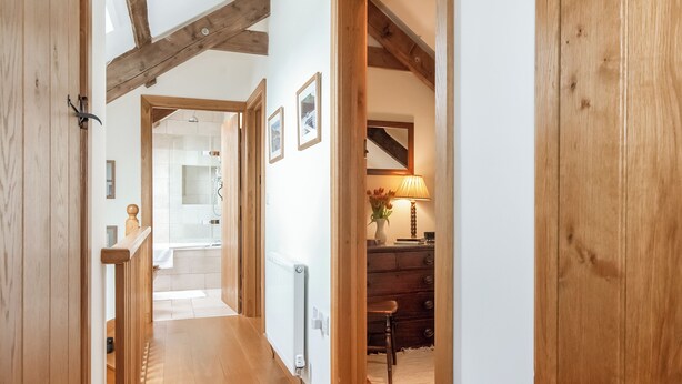 A wooden hallway with a staircase leading to a bathroom and a dining area. - 3 bedroom accommodation in Mathry, nr St Davids (Mathry, nr St Davids)