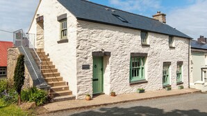 A stone house with a green door, a staircase, and a small garden. - 3 bedroom accommodation in Mathry, nr St Davids (Mathry, nr St Davids)