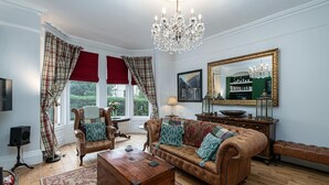 A traditional living room with a leather sofa, a wooden coffee table, and a large mirror.