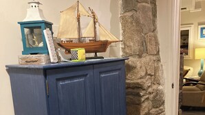 Ein blauer Schrank mit Schubladen, ein Schiffmodell und eine Laterne darauf.
