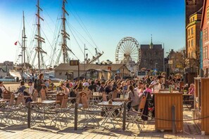 Situated in a historic public square, this outdoor café offers seating amidst stunning views of the surrounding architecture and a large Ferris wheel.