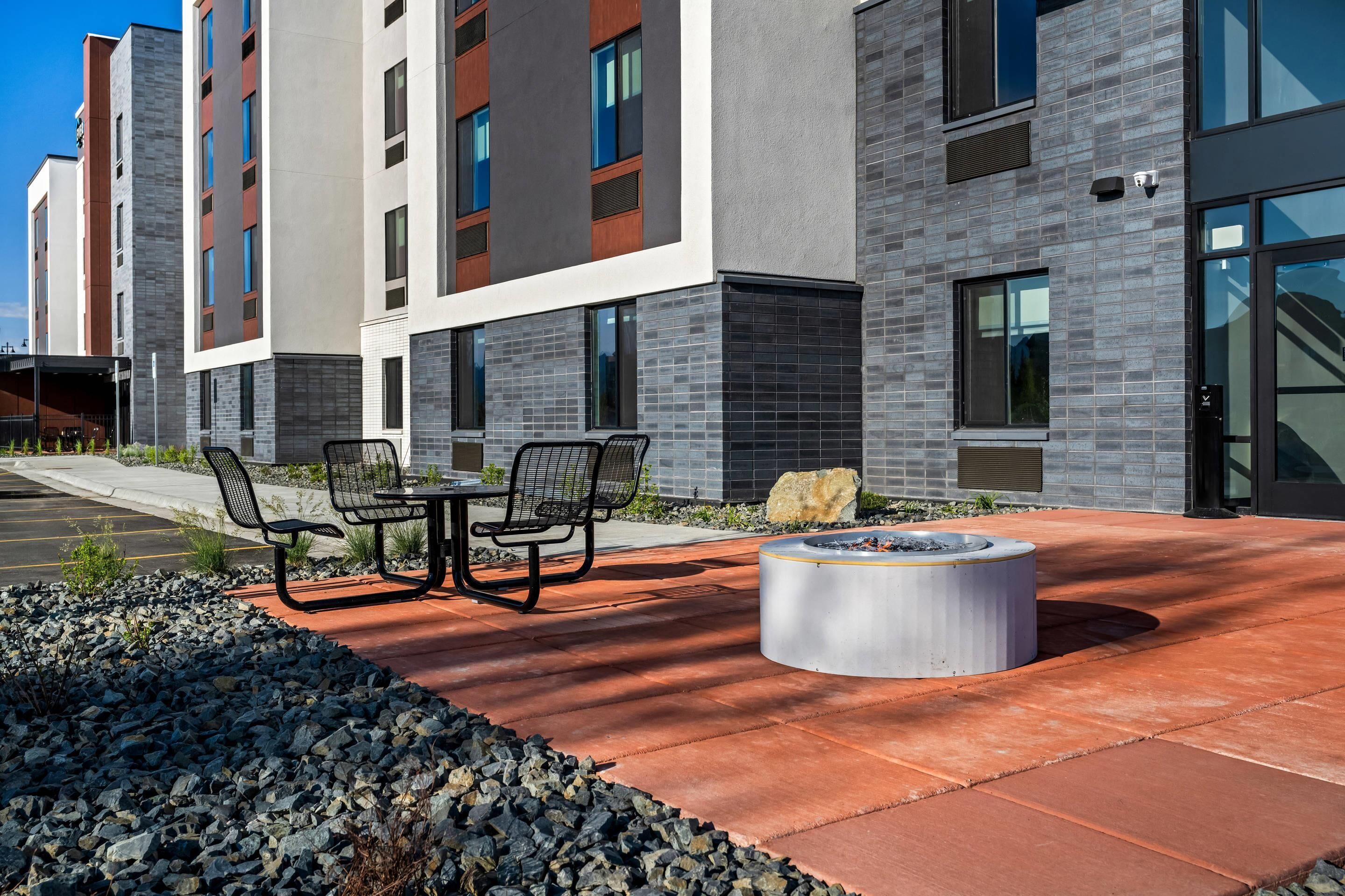 A modern building with a fire pit and outdoor seating area.
