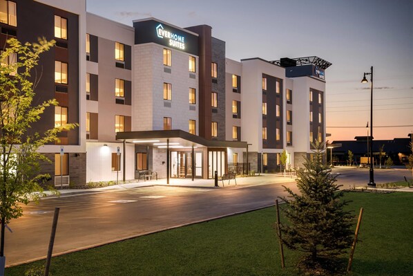 A modern hotel with a flat roof, multiple floors, and a well-lit entrance. - Everhome Suites Bozeman (Bozeman)