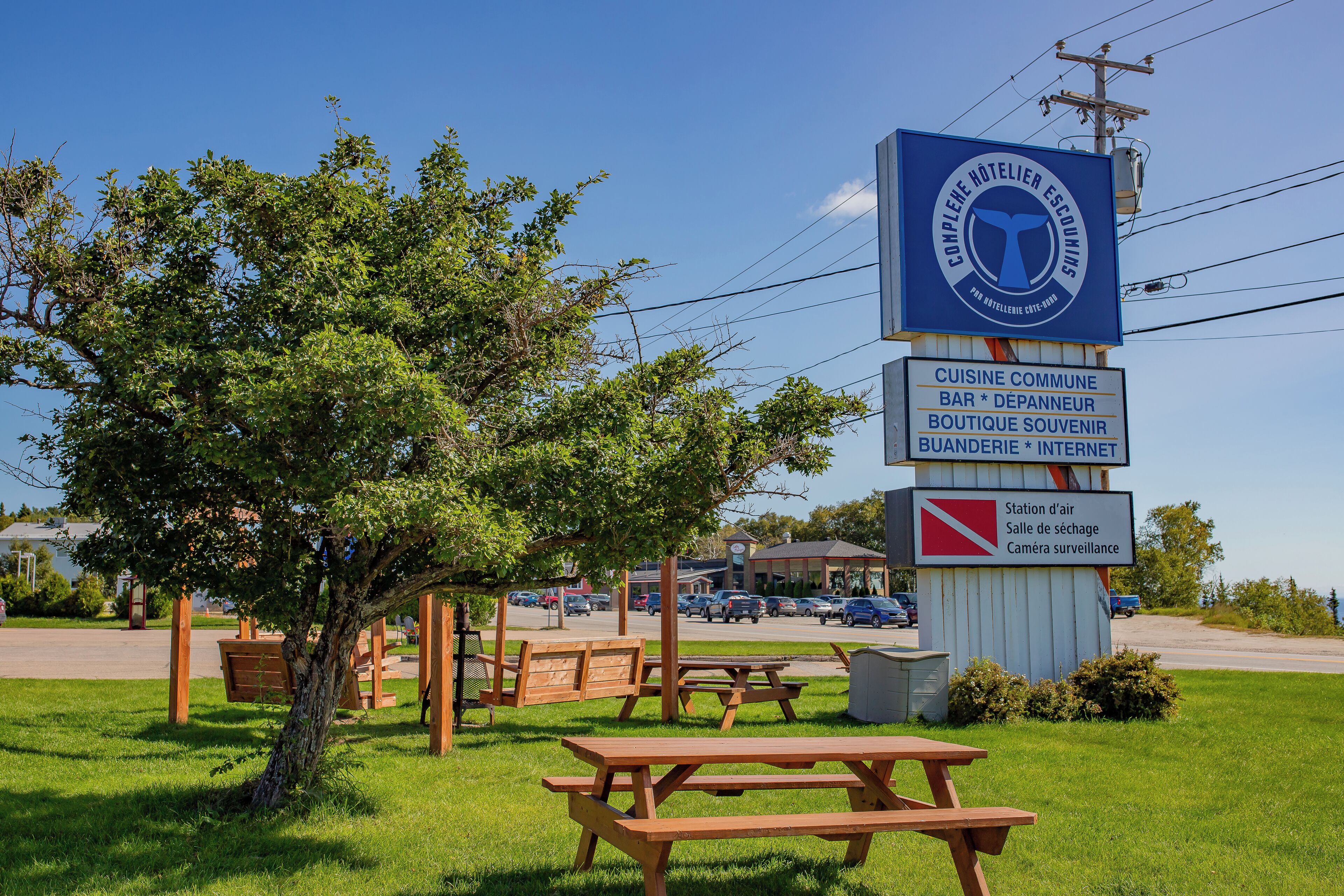A hotel sign with amenities including a communal kitchen, bar, souvenir shop, bakery, and internet access.