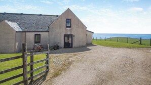 A two-story house with a gravel driveway and a wooden fence. - Barnstable - UK46888 (Shannochie)