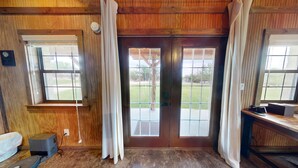A room with wooden walls, a door with glass panels, a window, and a desk with a computer. - VIP Cabin A w/ Lake Views & Private Lake Access with Dock (Ingram)
