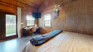A bedroom with a bed, a desk, and a mounted deer head. - VIP Cabin A w/ Lake Views & Private Lake Access with Dock (Ingram)