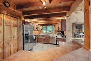 Une cuisine moderne avec des meubles en bois, des appareils électroménagers en acier inoxydable et un grand îlot central.