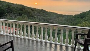 A balcony with a white balustrade overlooking a hilly landscape during sunset. - BLUE BREEZE (Dapoli)