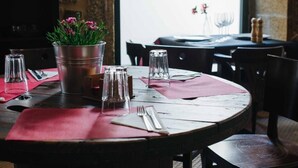 Ett matbord dukat med en metallhink fylld med blommor, genomskinliga glas och en röd servett.
